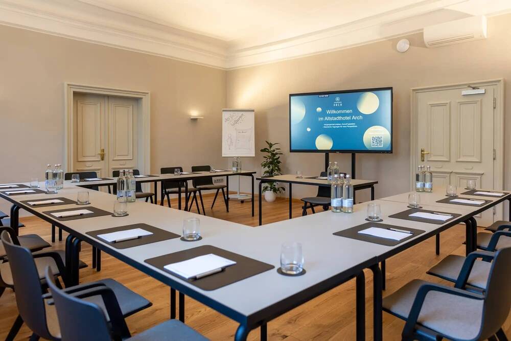 Tagungsraum im Altstadthotel Arch mit Tischen, Stühlen und technischer Ausstattung für erfolgreiche Meetings und Konferenzen.